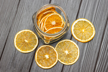 Fototapeta na wymiar Dry orange slices on the table and in a glass jar.
