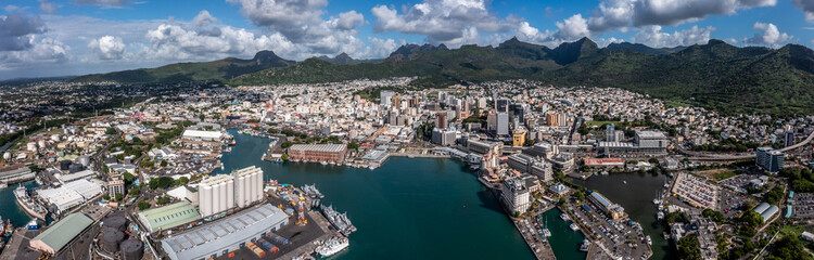 Port Louis, Mauritius, panoramic aerial view of the old and modern buildings around Caudan Waterfront, Harbor and City of Port Louis, Capital of Mauritius with mountains in the background.  - obrazy, fototapety, plakaty
