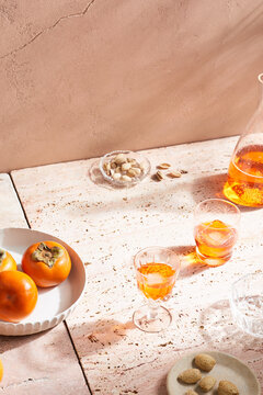 Shot glasses filled with orange alcohol drink and ice cubes