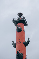 Rostral column vintage on the embankment with sculptures.