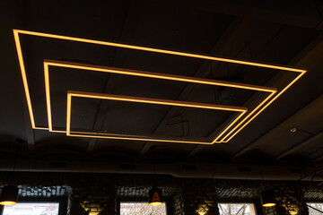 Unusual rectangular design lamps on the ceiling in an expensive restaurant. Interior design in a...