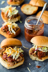 Several toasted pulled pork sliders with homemade barbecue sauce.