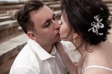 A couple in love,  The bride and groom are dressed in a wedding suit and dress, hugging, kissing ech other and posing together
