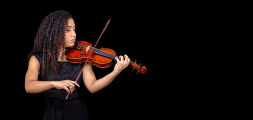 African American girl violinist plays violin on black background. Banner. Copyspace.