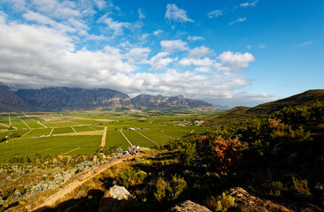 A view over Slanghoek Valley, Western Cape, in soft sunlight, showing farms and vineyards.