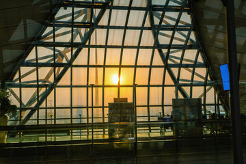 Scenic Sunrise over Suvarnabhumi Airport seen from inside through the window framework