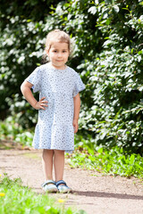 Portrait of a girl in a light summer dress, a small child in full growth