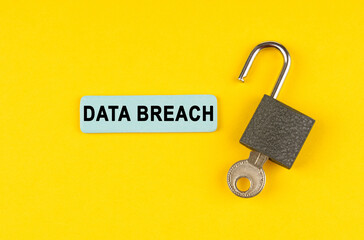 On the yellow surface lies an open lock with a key, next to it is a sticker with the inscription - Data breach