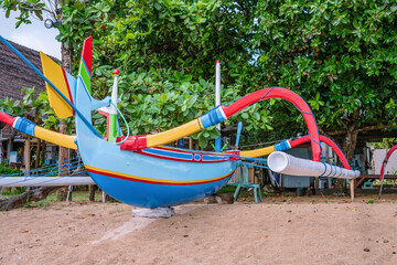 Traditional Balinese boat taken from water on a Sanur beach in Bali, Indonesia. Water drops on the...