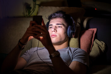 Fototapeta premium Young handsome man watching movie or listening to music