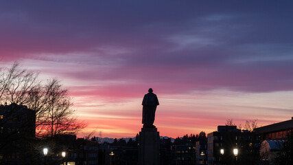 Fototapeta na wymiar Purple and Pink Sunset with Statue Silhouette at University of Washington in Seattle, WA