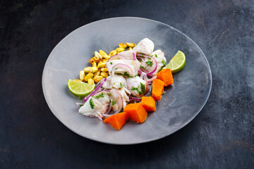 Traditional Peruvian gourmet ceviche sea bass filet piece with sweet potatoes and cancha marinated...