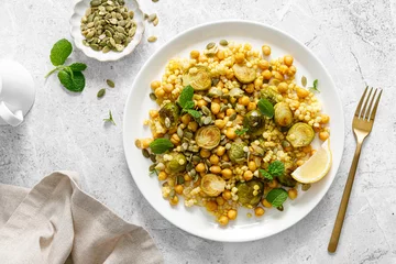 Gartenposter Couscous brussels sprouts and chickpeas warm salad with pumpkin seeds. Healthy vegetarian diet food. Top view © Sea Wave