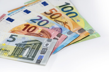 Obraz na płótnie Canvas Some banknotes in euro currency on a light gray background, finance concept, copy space, selected focus, narrow depth of field