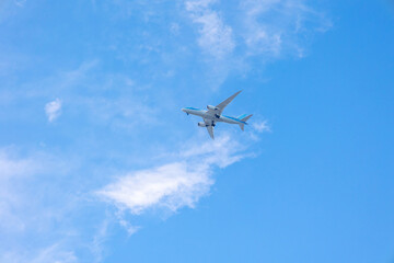 Fototapeta na wymiar View of airplane flying in blue sky among white clouds. . High quality photo