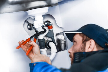 Plumber hands with wrench repair sink in bathroom.