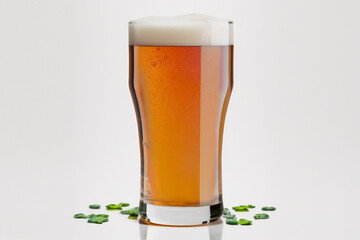 A glass of beer surrounded by Shamrocks for St. Patrick's Day