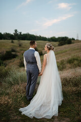 bride blonde girl and groom in a field