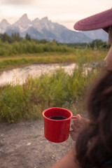 Hiker enjoying sunrise coffee in grand teton national park