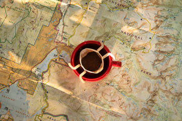 traveler planning road trip with a map and red coffee cup