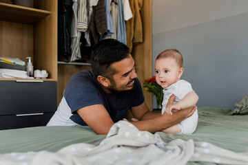 Obraz premium hispanic Loving father embracing his cute baby son in Mexico Latin America