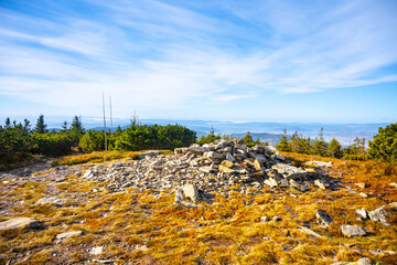 Small stone pyramid on the summit of Pec Mountain. Cold and sunny autumn day in Hruby Jesenik...