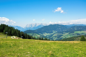 Fototapeta na wymiar Panorama of Austrian Alps with forest and green meadow. Grafenberg Hill, Wagrain.