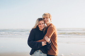 couple in a loving embrace at the beach with the waves in the background