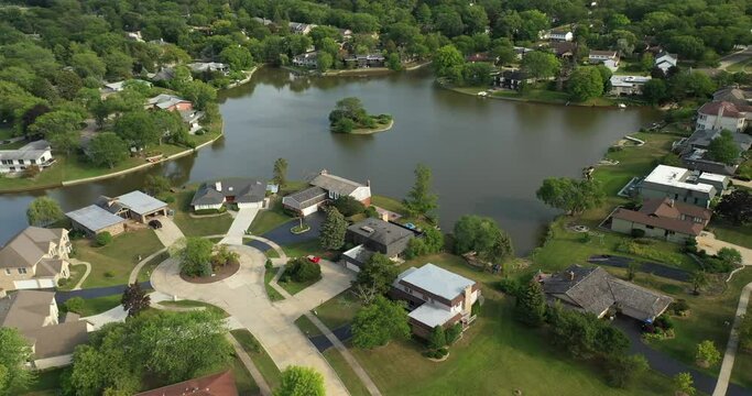 Aerial view of a neighborhood with pond beside a highway in suburban Chicago during summer.