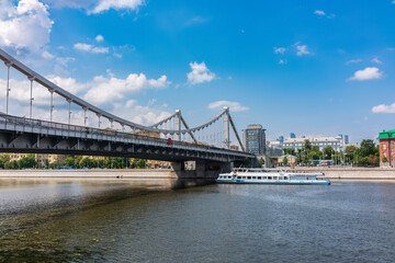Fototapeta na wymiar Krymsky Bridge or Crimean Bridge in Moscow and Cruise ship sails on the Moscow river