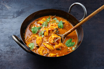 Traditional spicy Indian prawn Madras curry Rogan Josh with king prawns served as close-up in a...