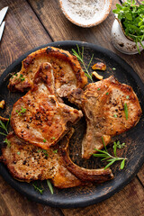 Pork chops grilled or seared bone in on a serving plate