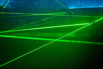 Bright green neon laser lights illuminate the darkness creating lines and triangle shapes in sci-fi...