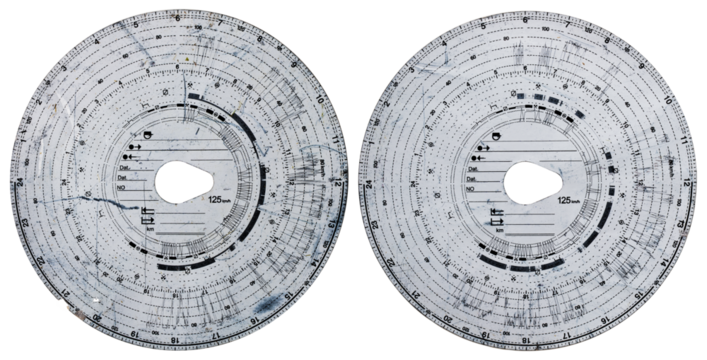 Two tachograph discs with a car driving record on an isolated background.