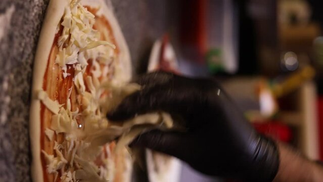 Italian chef making margaritta pizza with tomato sause and mozzarella, traditional food in italy, high kitchen gastrobar restaurant, street food delivery.