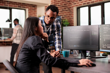 Team of database admins debugging algorithm working in software developing office. Two cloud...