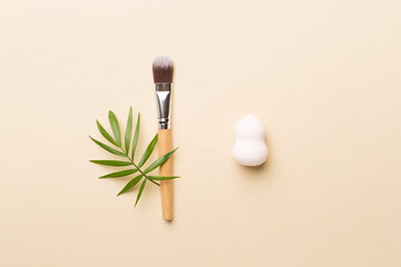Obraz na płótnie Canvas Make up brush and sponge on color background, top view