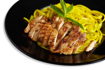 Linguine Pasta With Grilled Chicken on a Black Plate Isolated White Background Close Up