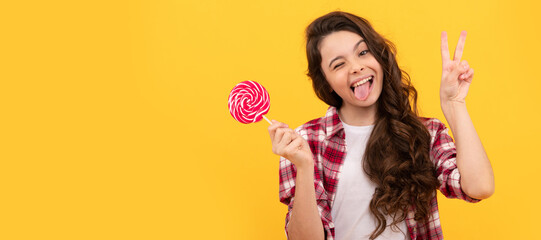 hipster kid with long curly hair hold lollypop. sugar candy on stick. caramel candy shop. Teenager...