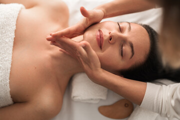 Massage therapist rubbing jaw of woman - Powered by Adobe