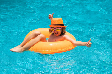 Child boy splashing in swimming pool. Swim water sport activity on summer vacation with children.