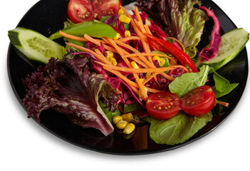 Green Salad with Carrot and Cucumber in a Black Plate Isolated White Background Close Up