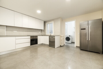Large kitchen with modern furniture without handles with white doors and drawers, stoneware floors...