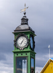 Fototapeta na wymiar Green antique clock tower and meteorology station by the port and harbor in Punta Arenas