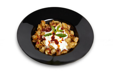 Turkish Dumplings (Mantı) in black plate isolated white background