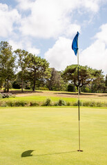 Obraz premium Campo de deporte de golf con un verde e impecable césped en verano