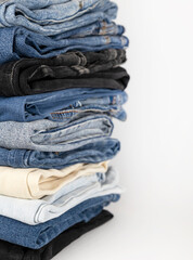 Denim pants stack on white background. Shopping concept.