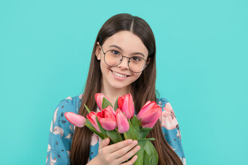 portrait of happy child in glasses with tulips. mothers or womens day. kid hold flowers