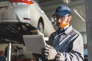 auto serviceman writing the results of chassis inspection in a car repair shop, medium shot. High quality photo