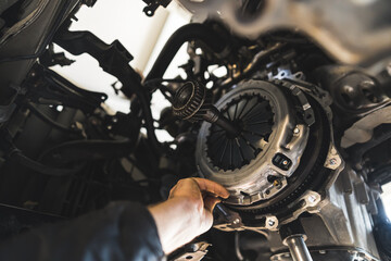 closeup shot of an auto mechanic installing a new clutch kit for a car, auto repair shop. High quality photo - obrazy, fototapety, plakaty